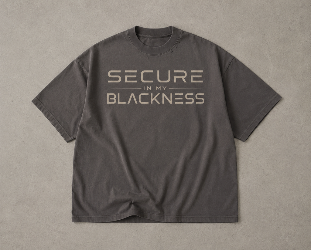 Gray t-shirt with 'Secure in my Blackness' text on a beige background